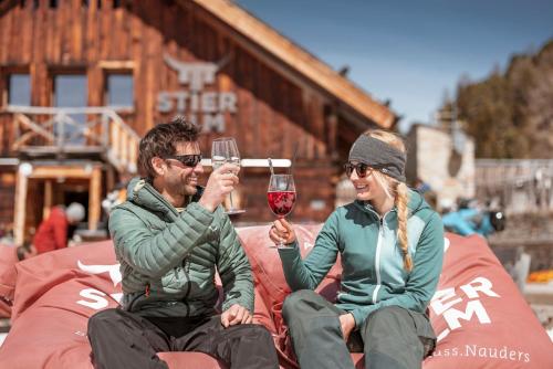a man and a woman holding up glasses of wine at Palazi Apartments & Spa in Nauders