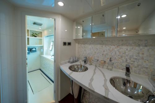 Holiday yacht in Dubai في دبي: حمام مع مغسلتين ودش