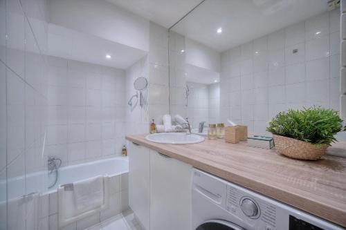 La salle de bains blanche est pourvue d'un lavabo et d'un lave-linge. dans l'établissement IMMOGROOM - MODERN with TERRACE - AIR CONDITIONING - WIFI, à Cannes