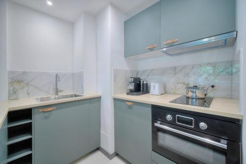 une cuisine avec des armoires bleues et un évier dans l'établissement IMMOGROOM - MODERN with TERRACE - AIR CONDITIONING - WIFI, à Cannes