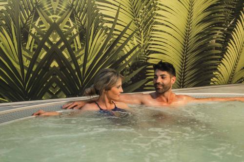 a man and a woman sitting in a hot tub at Magic Tropical Splash in Cala de Finestrat