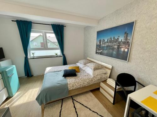 a bedroom with a bed and a large window at Arenaapartments in Gdańsk