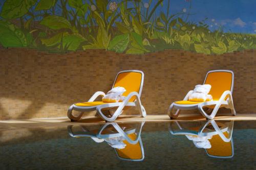 two teddy bears sitting on chairs in a pool at Hotel Stella Montis in Campitello di Fassa