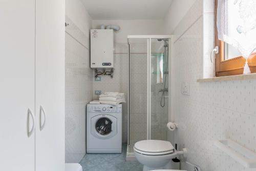 een badkamer met een wasmachine en een toilet bij Baita Bocheto in Levico Terme
