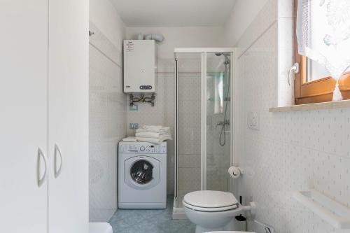 a bathroom with a washing machine and a toilet at Baita Bocheto in Levico Terme