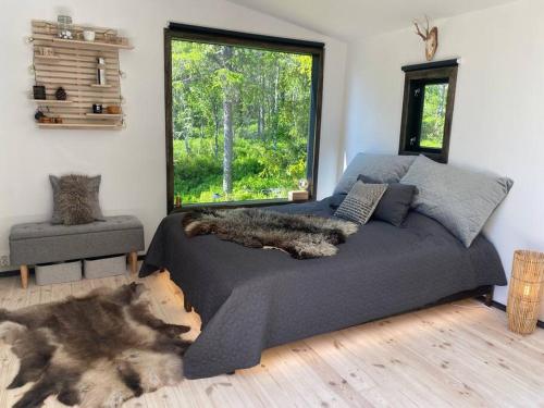 Forest cabin with stunning mountain view & Sauna في تورسبي: غرفة نوم مع سرير مع كلب يستلقي عليها