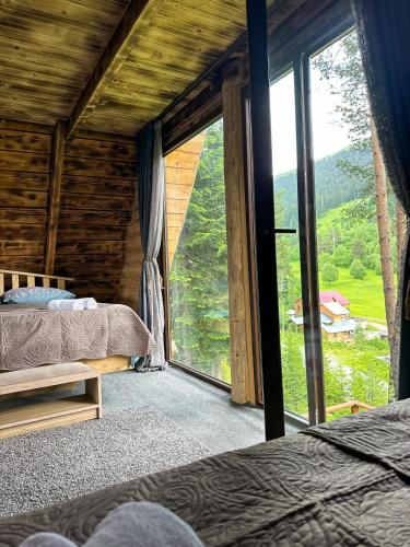 ein Schlafzimmer mit zwei Betten und einem großen Fenster in der Unterkunft Hut In Hatsvali in Mestia