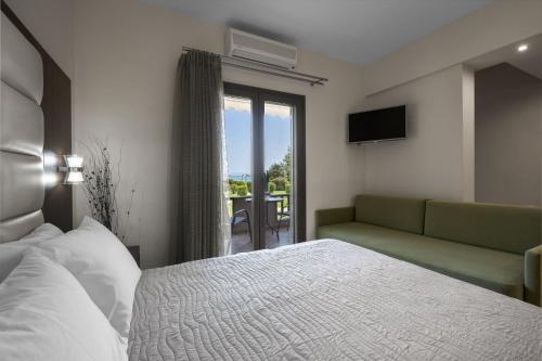 a bedroom with a bed and a couch and a patio at studios ioanna in Vourvourou