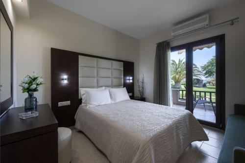 a hotel room with a bed and a balcony at studios ioanna in Vourvourou