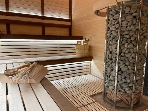a sauna with a stack of logs and a rack of fire wood at Готель-спа "Еліт" in Kolʼchyno