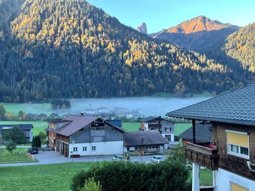 a village with a lake and mountains in the background at Haus Ritter 286 in Schoppernau