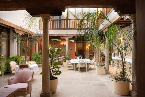 a restaurant with tables and chairs and potted plants at La Corrala del Realejo in Granada