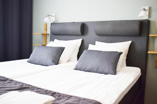 two beds with gray and white pillows next to each other at Gästis Tierp in Tierp