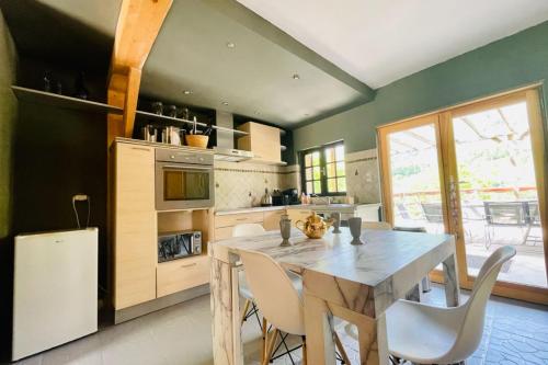 eine Küche mit einem Tisch und Stühlen sowie einem Kühlschrank in der Unterkunft Bright chalet with terrace and garden in Briançon in Briançon