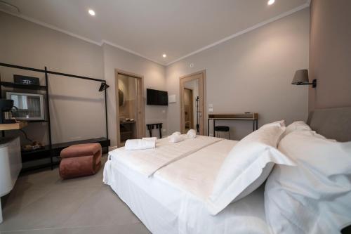 a bedroom with a large white bed with white pillows at Porto Ercole Guest House in Porto Ercole