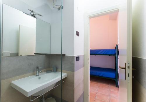 bagno con lavandino e specchio di Residence Le Vele a Stintino