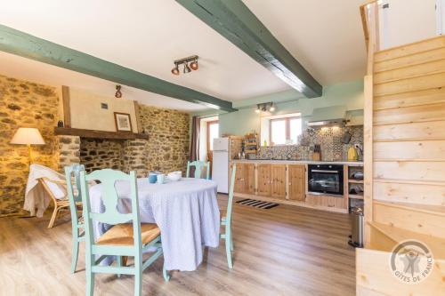 une cuisine et une salle à manger avec une table et des chaises dans l'établissement Le jardin des fées, à Savigny-le-Vieux