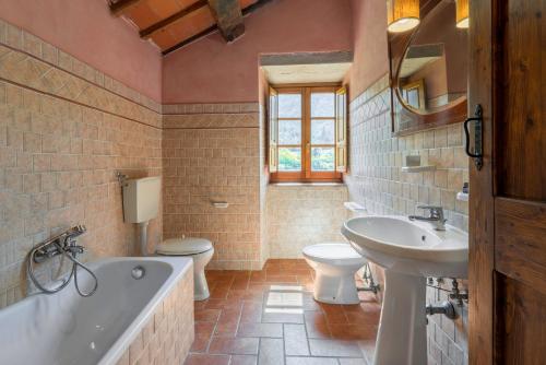 a bathroom with a tub and a toilet and a sink at Colle Degli Ulivi - pool, nature, relax holiday home Cortona, Italia in Cortona