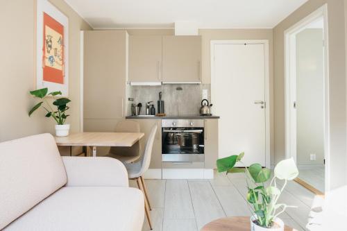 uma cozinha e sala de estar com um sofá e uma mesa em Stay Urban - Perfect location em Bergen