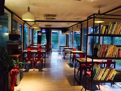 un restaurant avec des tables, des chaises et des livres dans l'établissement How Has Homestay, à Chishang