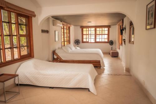 two beds in a room with two windows at casa filippi in Honda