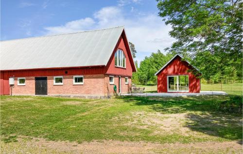a red barn with a metal roof at Cozy Home In Lammhult With Sauna in Lammhult