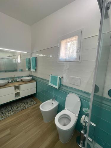 łazienka z toaletą i umywalką w obiekcie Villetta Palmina w mieście Porto Azzurro