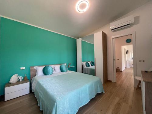 a bedroom with a large bed with a blue wall at Villetta Palmina in Porto Azzurro