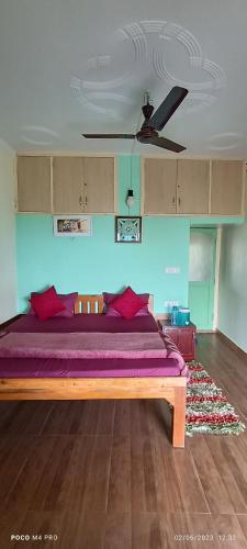 a bedroom with a bed with purple sheets and a ceiling at The Moon Light Home stay in Bhīm Tāl
