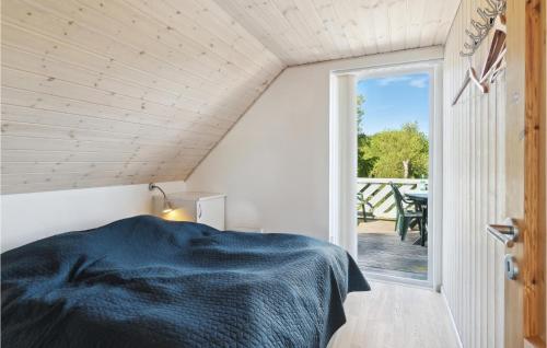 Fjellerup StrandにあるAwesome Home In Glesborg With 4 Bedrooms, Sauna And Wifiのベッドルーム1室(ベッド1台付)、パティオ(テーブル付)