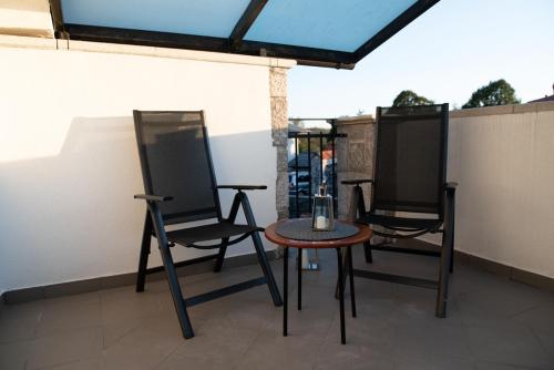 - une terrasse avec 2 chaises et une table dans l'établissement Castle house rooms, swimming pool & sauna & tennis court & wine cellar, à Sežana