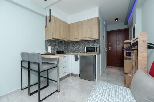 a kitchen with wooden cabinets and a counter top at EllMar - new & modern studio in the center in Chalkida