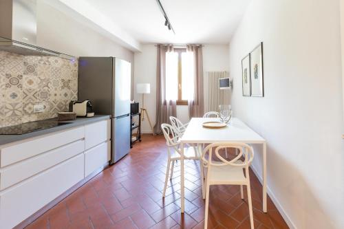 a kitchen with a table and chairs in a room at La casa del Vescovo in Imola