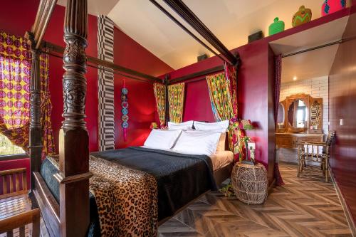 1 dormitorio con 1 cama con paredes rojas en Aal Cachucho en San Agustín de Guadalix