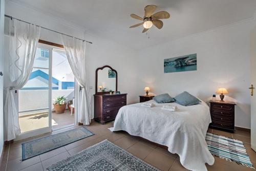 a bedroom with a bed and a mirror and a window at Casa Alto do Perogil Tavira-3 bedroom house with pool & free wifi in Tavira