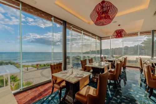 a restaurant with tables and chairs and large windows at Muthu Clube Praia da Oura in Albufeira