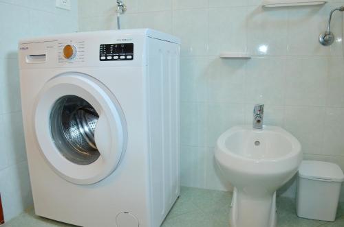 a bathroom with a washing machine and a toilet at Condominio Al Mare in Bibione