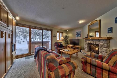 a living room with two couches and a fireplace at Snow Creek Village #20 By Bear Country in Sun Peaks