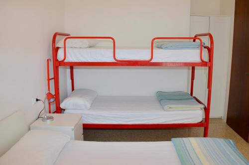 a room with two bunk beds and a room with two beds at Condominio Al Mare in Bibione