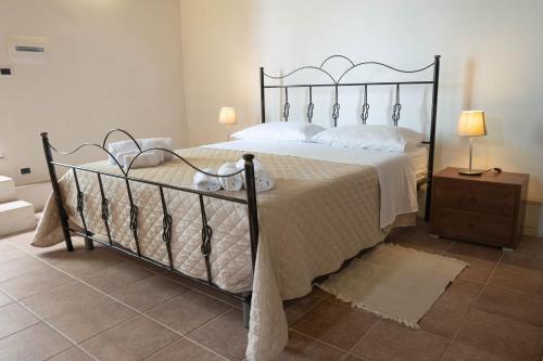 a bedroom with a large bed with a metal frame at Il Paese Alberga! in Caulonia