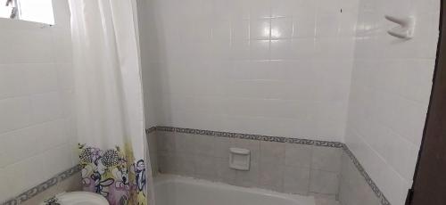 y baño con bañera blanca y aseo. en Departamento B. Sur en San Miguel de Tucumán