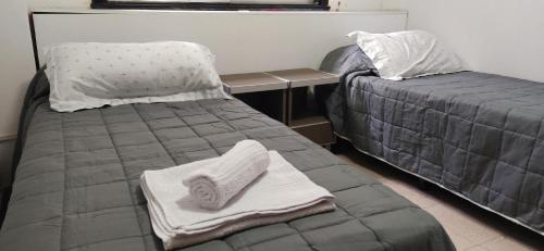 Una cama con toallas junto a un escritorio. en Departamento B. Sur en San Miguel de Tucumán