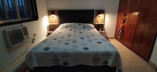 1 dormitorio con 1 cama con edredón azul y blanco en Departamento B. Sur en San Miguel de Tucumán