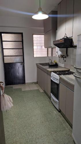 cocina con fregadero y fogones horno superior en Departamento B. Sur en San Miguel de Tucumán
