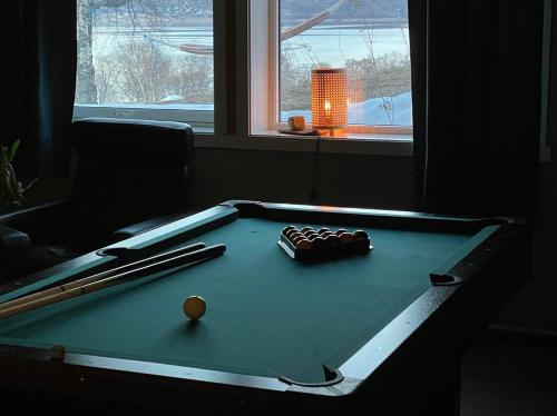 a pool table with two bats and a ball on it at Tjeldøya Slott in Hov