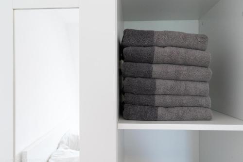 a stack of towels on a shelf in a bathroom at Edle DG Maisonette mit Balkon, Wohnzimmer, Arbeitszimmer, Waschmaschine, Top Ausstattung, zentral in Fürstenwalde