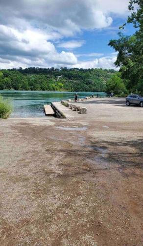 a park with benches on the shore of a river at Cozie cottage at Niagara-On-The-Lake in Queenston