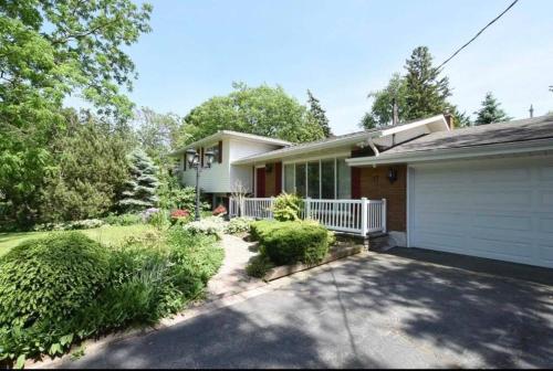 una casa con garaje blanco y entrada en Cozie cottage at Niagara-On-The-Lake en Queenston