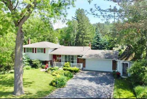 a white house with a tree in the yard at Cozie cottage at Niagara-On-The-Lake in Queenston