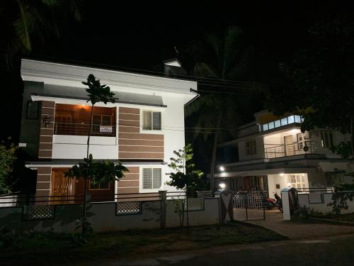 a white and brown house at night at Panchavati Homestay in Malpe